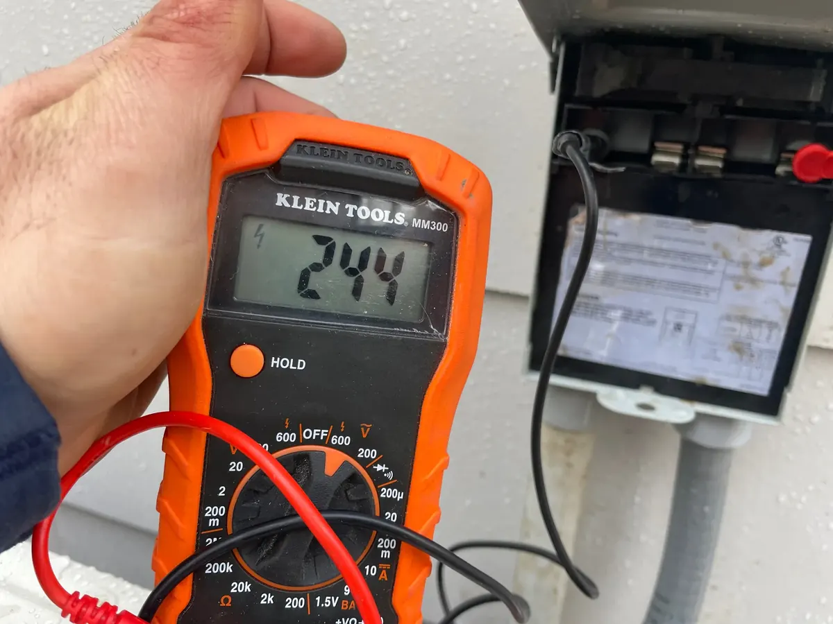 Licensed electrician using a professional multimeter to diagnose a faulty circuit in a Holbrook NY home — Berman Electric troubleshooting.