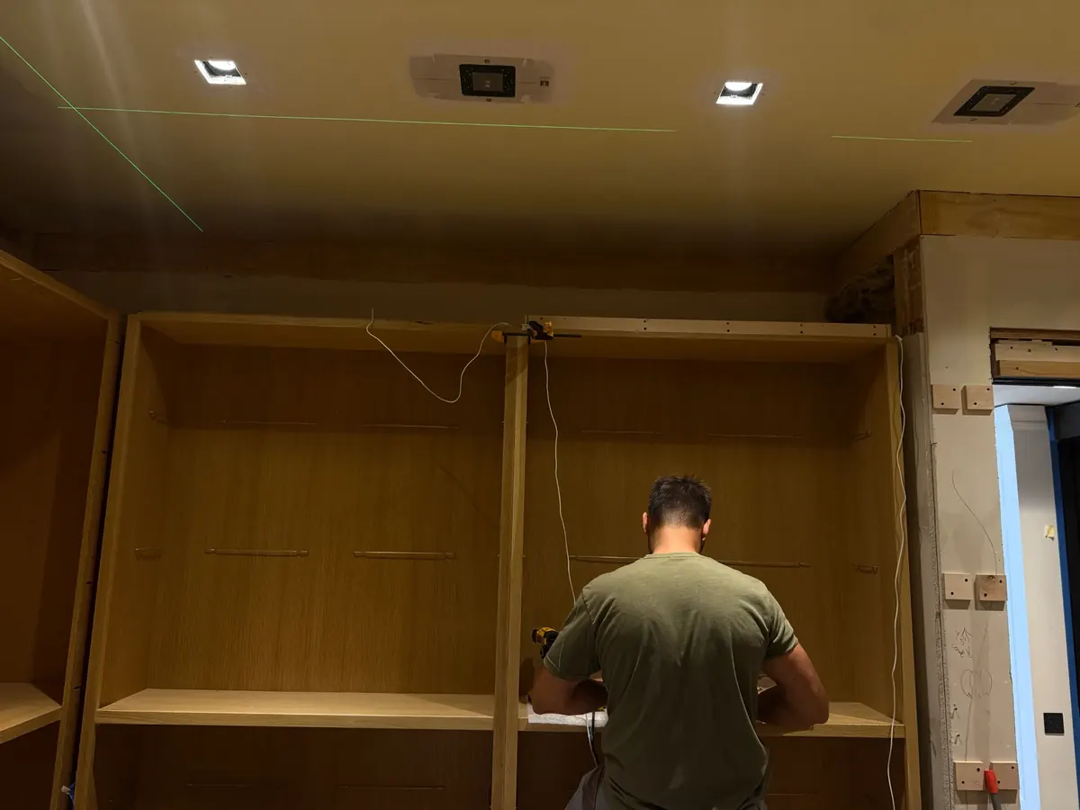 Laser-leveled recessed LED ceiling lights installed in evenly-spaced rows above custom millwork in a Smithtown NY home by Berman Electric.